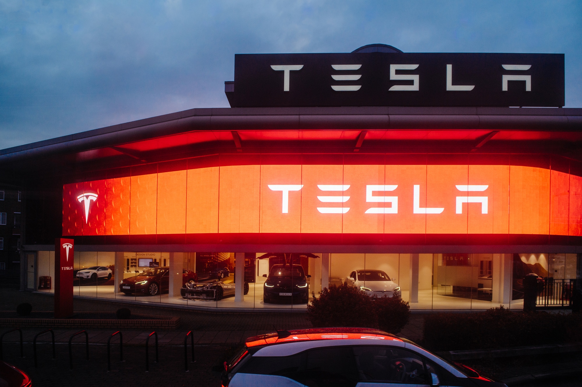 Tesla motors showroom with cars inside and illuminated logo bran