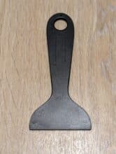 A plastic scraper for cleaning the resin tub