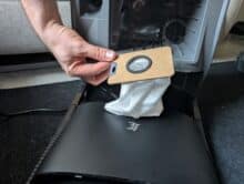 Removing the full dust bag from the station by hand