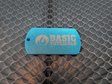 Engraved aluminum dog tag with "BASIC TUTORIALS" logo on honeycomb plate