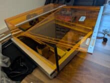 Toocaa L2 during installation - acrylic flap loosely in place, sticker for alignment visible, accessories ready for use